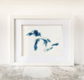 Framed Great Lakes cross-stitch art with blue bathymetric lake map on white fabric.