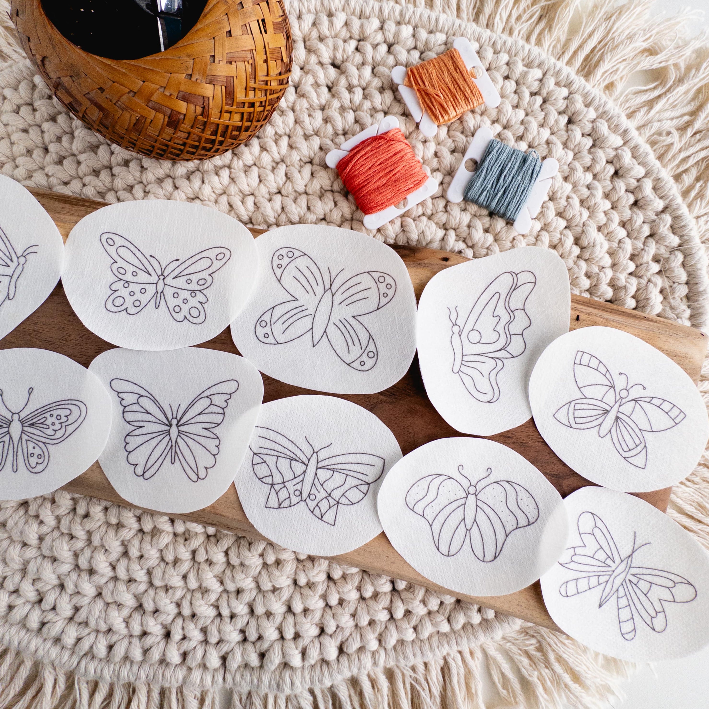 12 butterfly stick and stitch embroidery patterns on water-soluble paper, with orange and blue floss.