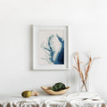 Framed Chesapeake Bay cross-stitch pattern, a minimalist blue bathymetry map on white fabric.