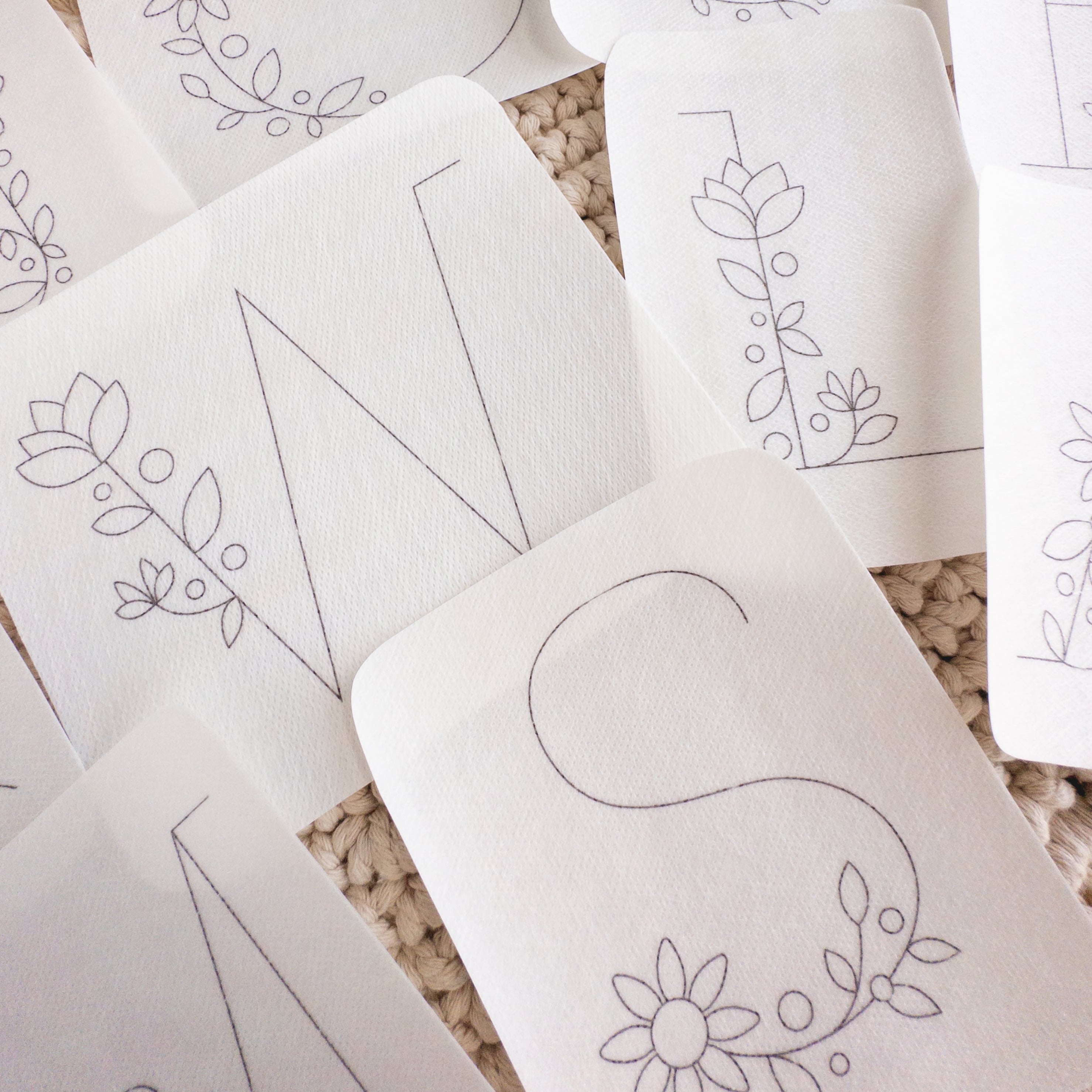 White stick and stitch embroidery patterns featuring large floral letters like W, S, and other monograms.
