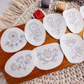 Scandinavian folk flower embroidery patterns on water-soluble stabilizer stickers, with floss and scissors.