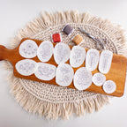 12 Scandinavian folk flower embroidery patterns on white water-soluble stabilizer stickers, with floss and scissors.