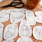 White water-soluble embroidery patches with 12 Halloween designs like pumpkins, ghosts, and a witch hat.
