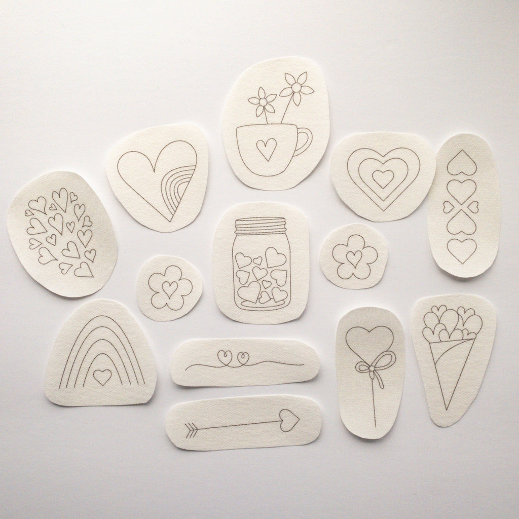 13 beige water-soluble heart embroidery stick and stitch patterns, ranging from 1.1" to 3" in diameter.