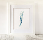 Framed Lake Champlain cross-stitch art, featuring a blue and green bathymetric map on white fabric.
