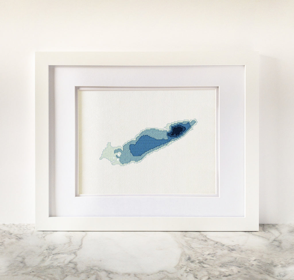 Framed Lake Erie cross-stitch art in shades of blue, showing bathymetric depths.