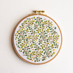Embroidered lemon grove botanical design on white fabric in a 6-inch wooden hoop.