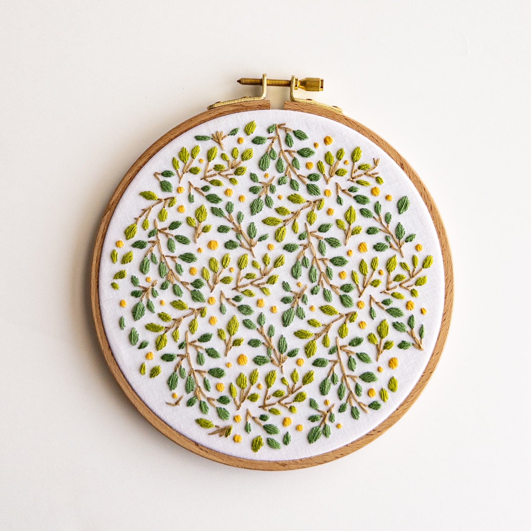 Embroidered lemon grove botanical design on white fabric in a 6-inch wooden hoop.