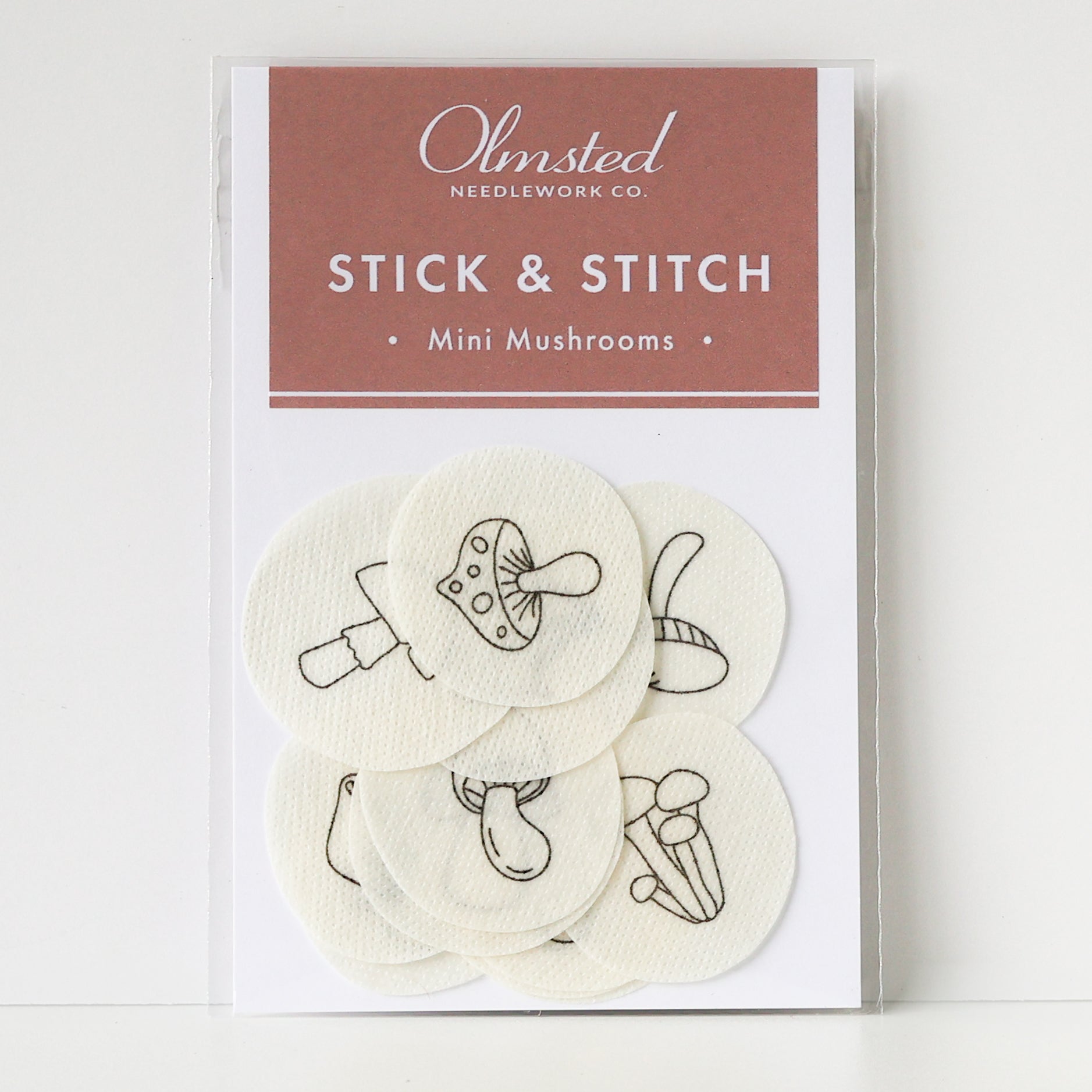 Olmsted Needlework Co. Stick & Stitch mini mushroom embroidery patterns on white water-soluble stabilizer patches.