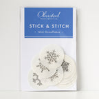 Pack of 12 white, round, water-soluble Stick & Stitch mini snowflake embroidery patterns, 1" diameter.