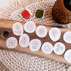 12 white water-soluble stick and stitch mini flower embroidery patterns on a wooden board.
