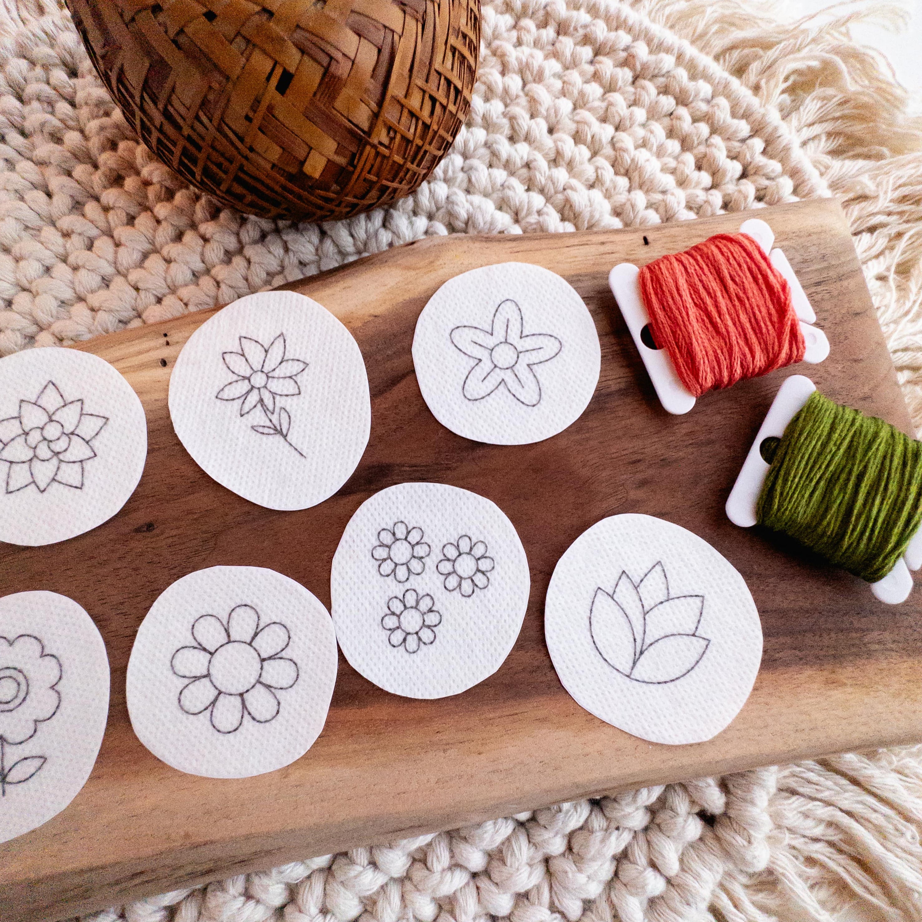 Mini flower stick and stitch embroidery patterns on water-soluble stabilizer, with orange and green floss.
