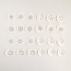 24 mini stick and stitch embroidery patterns on water-soluble stabilizer, featuring hearts, snowflakes, sunbursts, shamrocks, leaves, flowers, orange slices, and pumpkins.