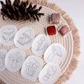 Nine mushroom stick and stitch embroidery patterns on white water-soluble stabilizer, with brown, red, and peach floss.
