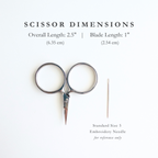 Pair of silver embroidery scissors with dimensions displayed on a white background with an embroidery needle for size comparison. Scissor dimensions are: Overall length 2.5", Blade Length: 1". 