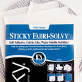 Sulky Sticky Fabri-Solvy printable embroidery transfer paper with instructions, on a stack of white sheets.