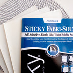 Sulky Printable Sticky Fabri-Solvy paper sheets on a textured gray and white background.