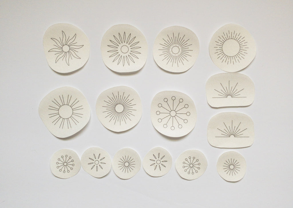 15 sun embroidery patterns on water-soluble stabilizer: large, small, and half-sun designs for fabric upcycling.