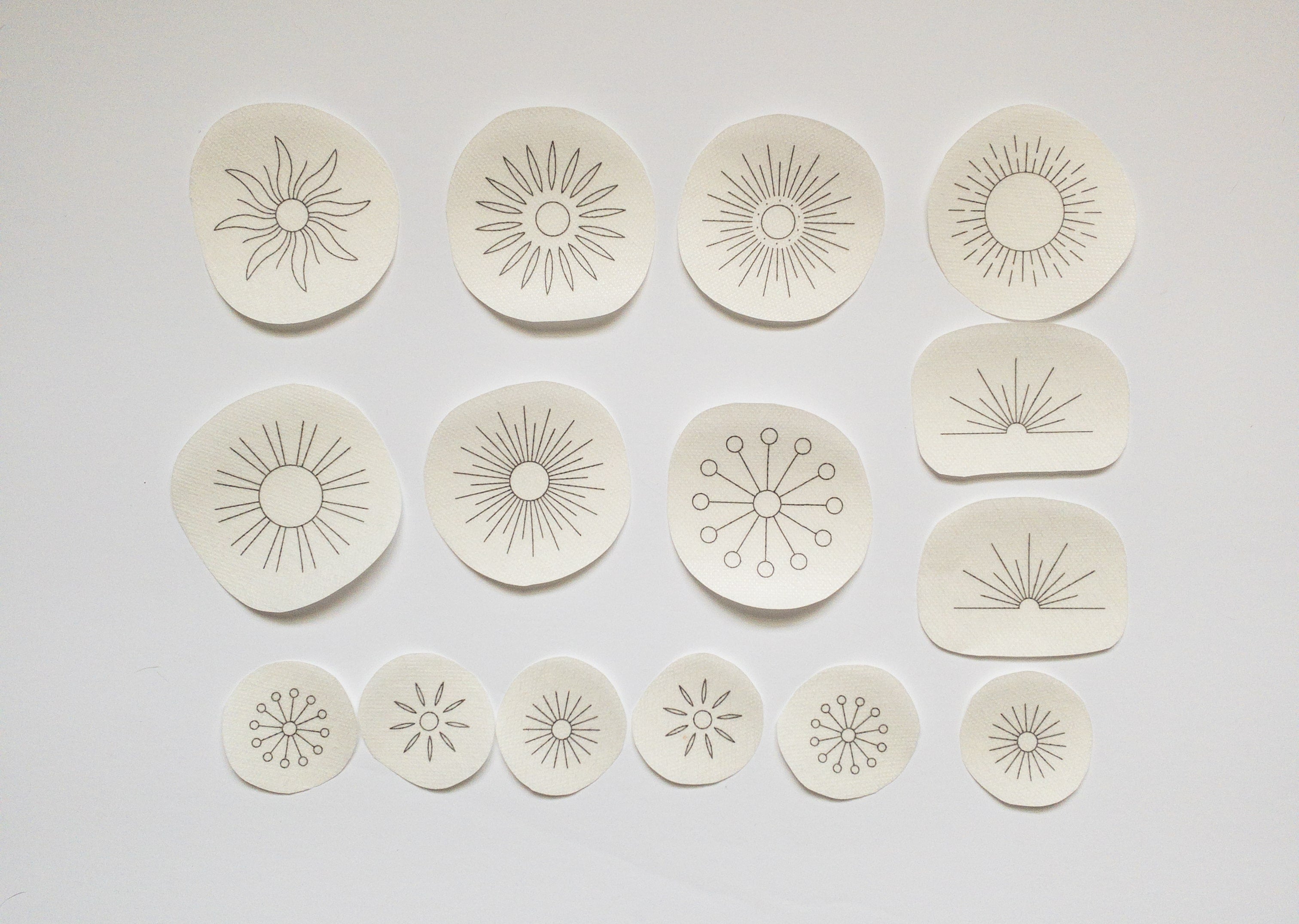 15 sun embroidery patterns on water-soluble stabilizer: large, small, and half-sun designs for fabric upcycling.
