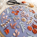 Twilight Meadow embroidery in a 6-inch hoop, featuring fall florals on moody fabric with sunflowers and wild cotton.