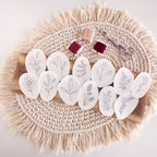 12 water-soluble wildflower stick and stitch embroidery patterns on a wood board with floss and scissors.